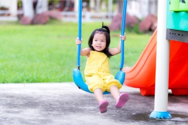 Child playing on swings, which is an enriching experience as Grace mentioned in the exclusive interview with ONE Intervention's founder