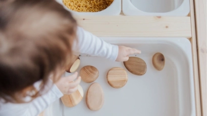 Baby engaging in sensory play with wooden discs