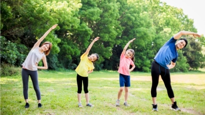 Family exercising at the park, since prioritising exercise is a way to improve physical quotient