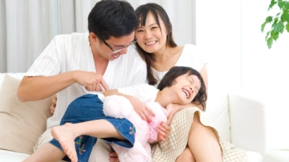 Image of a little girl in her parents' arms