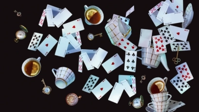 Image of cards and teacups across a dark tabletop