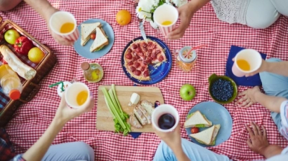 Picnic mat laid with sandwiches, juices and fresh fruit. Celebrate Father's Day 2025 by having a picnic