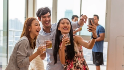 People at a party, holding drinks and taking a selfie. To avoid ADHD masking behaviour, one can explore healthy alternatives to masking, such as leaving these parties earlier