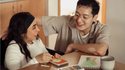 Caregiver and patient working on a colouring exercise together.