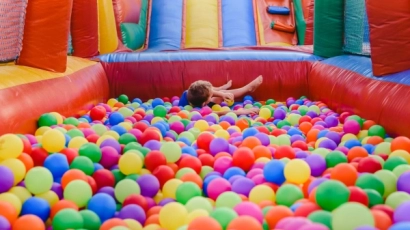 Child in a ball pit at a bouncy castle, which is at the Nickelodeon Playfest that one can go for a family day out
