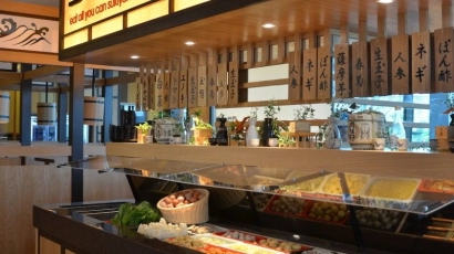 Suki-ya storefront, displaying a buffet of fresh meats and vegetables. Suki-ya is listed as one of the places where kids can eat free