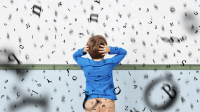 A young child in front of a whiteboard overwhelmed by letters, similar to kids with dysgraphia and dyscalculia.