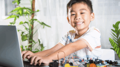 Boy smiling and working on robotics, having growth mindset from homework time