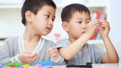 Two boys playing with play dough, which can be a great tool for sensory play